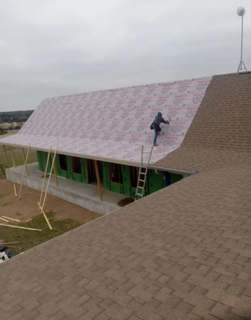 Worker preparing underlayment for a metal roof installation in Ocean City